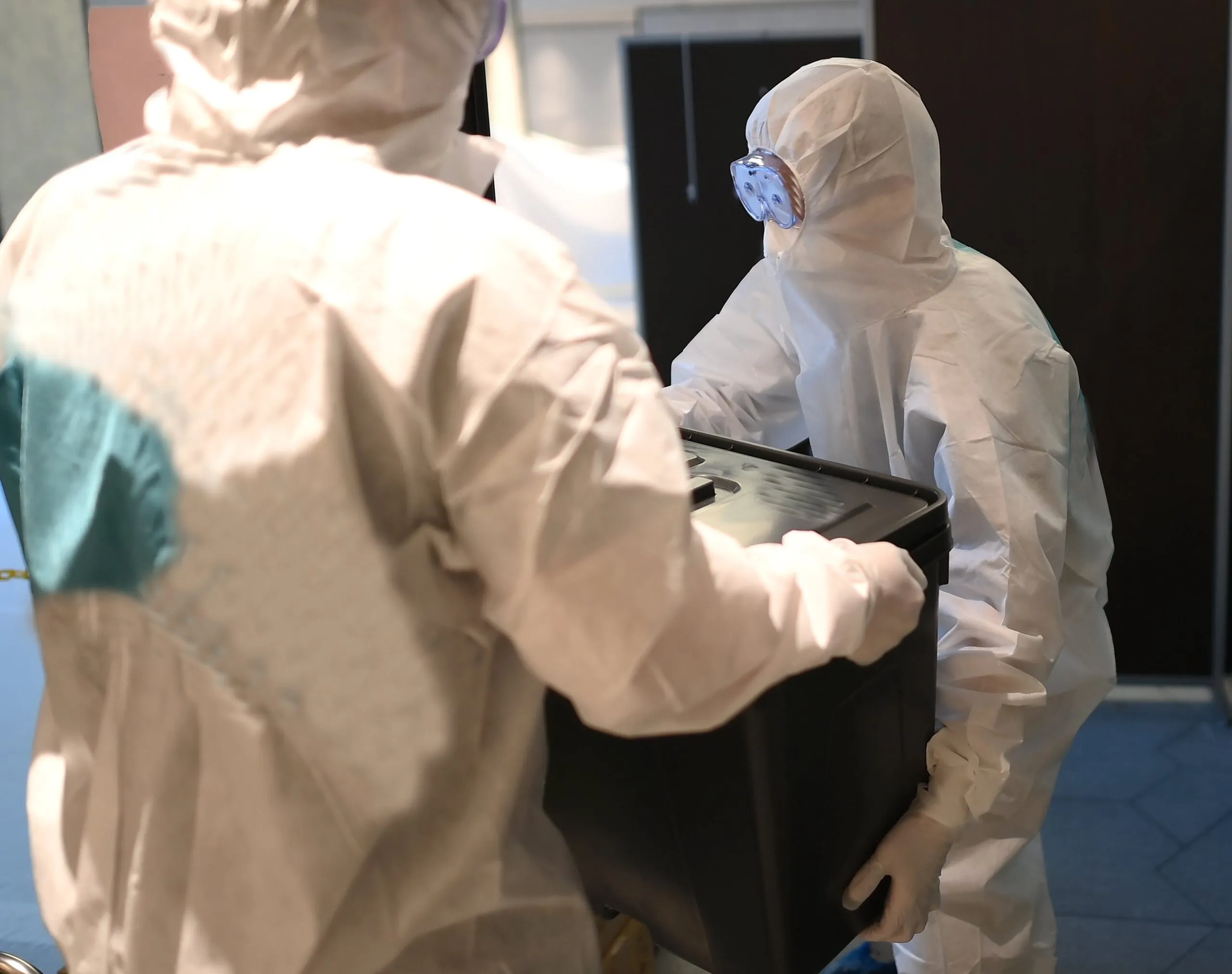 People in protective gear cleaning crime scene